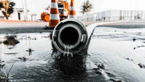 Selective closeup shot of a gray pipe with water coming out its hole